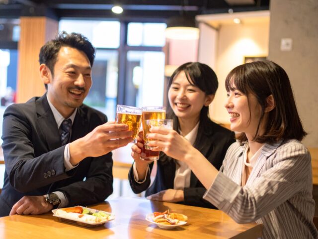 居酒屋で乾杯をする同僚
