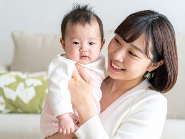 赤ちゃんを見て微笑む母親