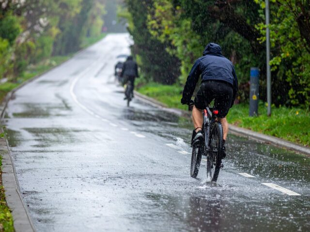 雨の日に自転車を漕ぐ人