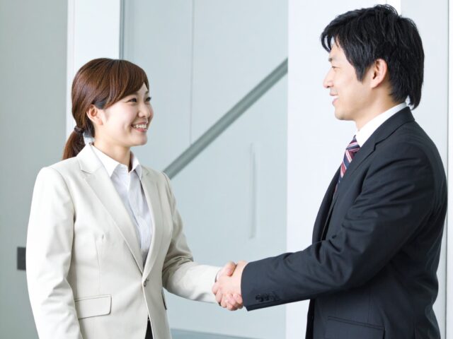 笑顔で握手をするビジネスパーソン