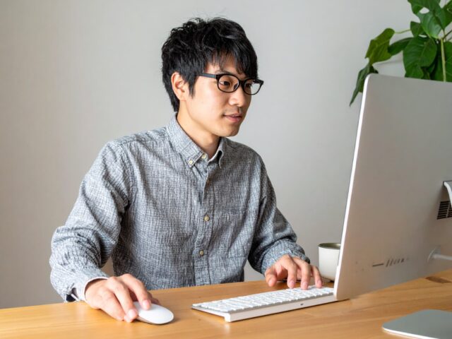 自宅デスクでリモートワークをする若手社員