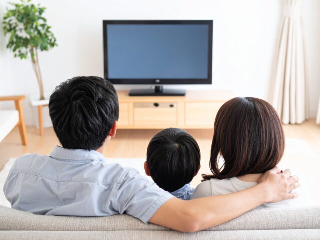 テレビを見ながらくつろぐ家族