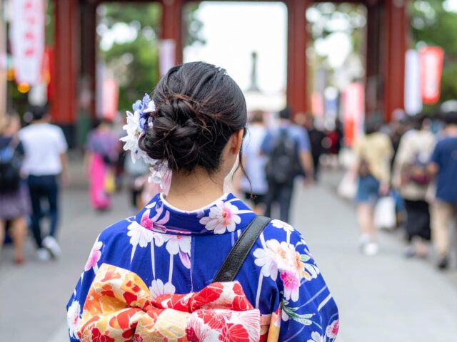 夏祭りで浴衣を着る女性の後ろ姿