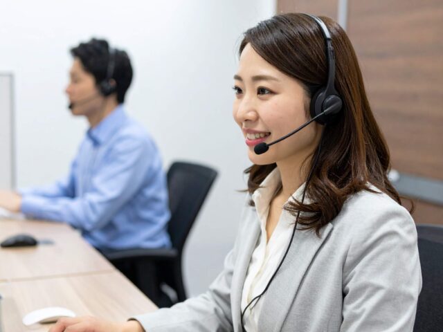 ヘッドセットをつけて話す女性スタッフ