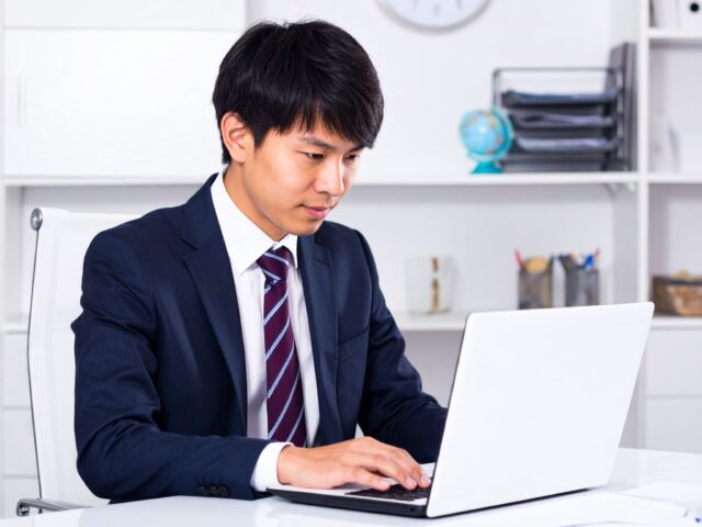ノートパソコンに向かうスーツ姿のビジネスマン