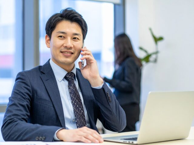 オフィスで電話をしているスーツ姿の男性