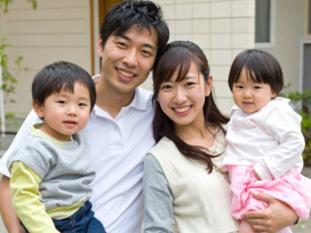 カメラ目線で微笑む四人家族