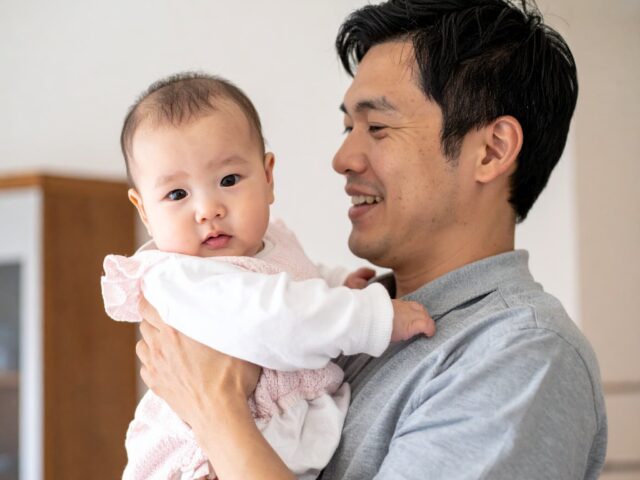 カメラを見つめる赤ちゃんと父親