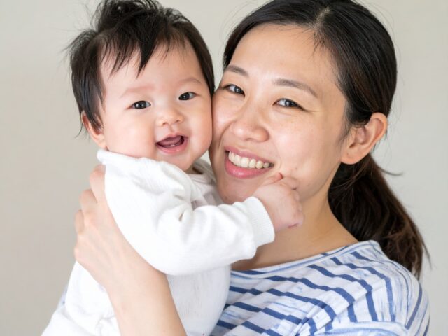 カメラ目線で頬を寄せ合う親子