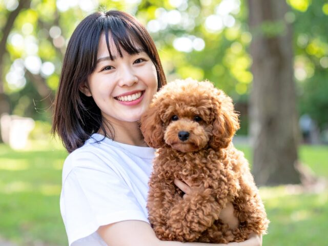 笑顔で愛犬を抱っこする女性