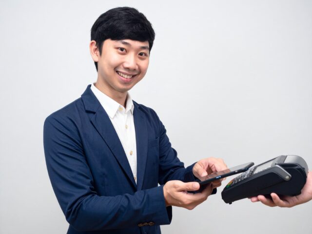 スマートフォンで電子決済する男性