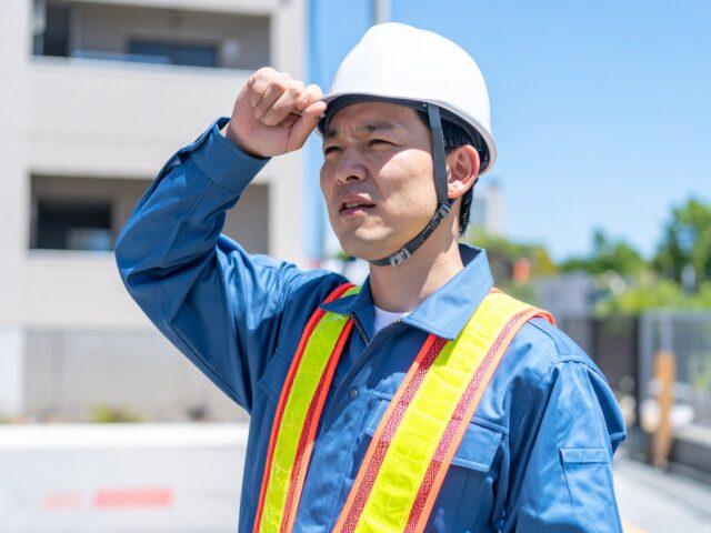 強い日差しの下で働く男性