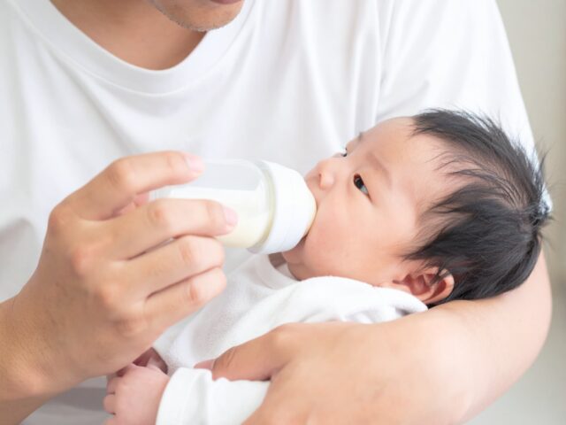 赤ちゃんに哺乳瓶で授乳する父親