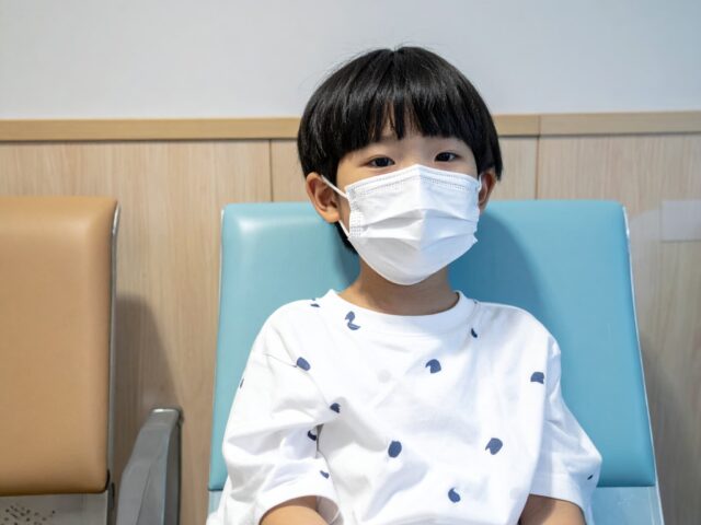 病院の待合室で待機している男の子