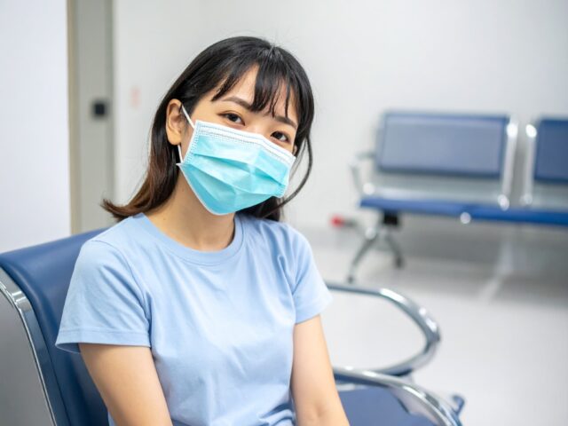 病院の待合室で待機している女性