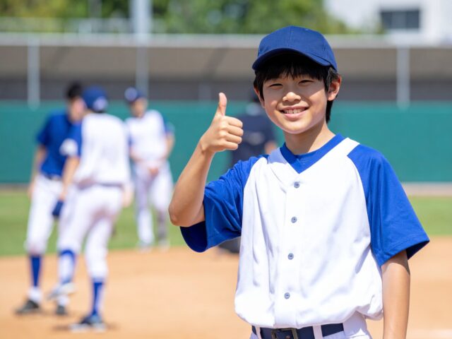 グッドサインをする野球少年
