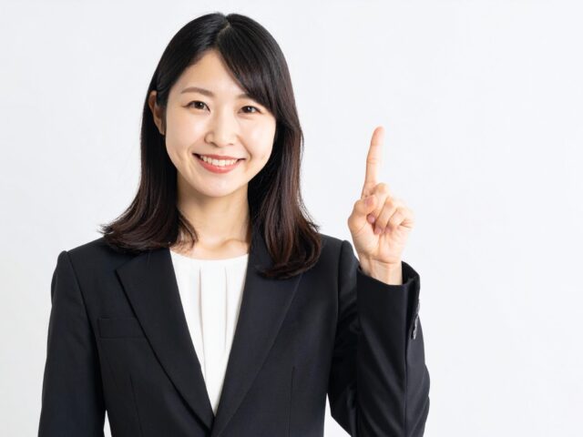人差し指を立ててポイントを説明するスーツ姿の女性