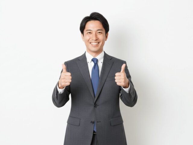 両手でグッドポーズをするスーツ姿の日本人ビジネスマン