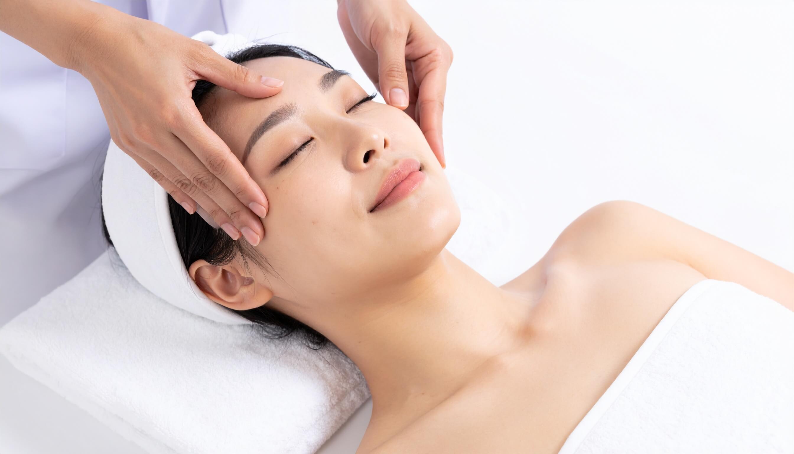 エステサロンでフェイシャルマッサージを受ける女性